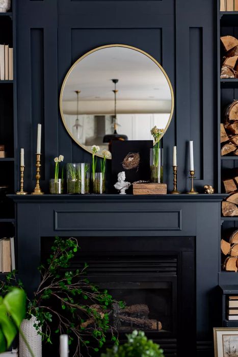 A dark-painted mantel adorned with plants for a striking and moody look.