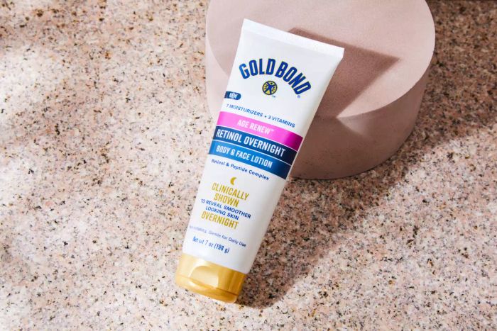 Gold Bond Age Renew Retinol Overnight Body and Face Lotion displayed on a marble surface
