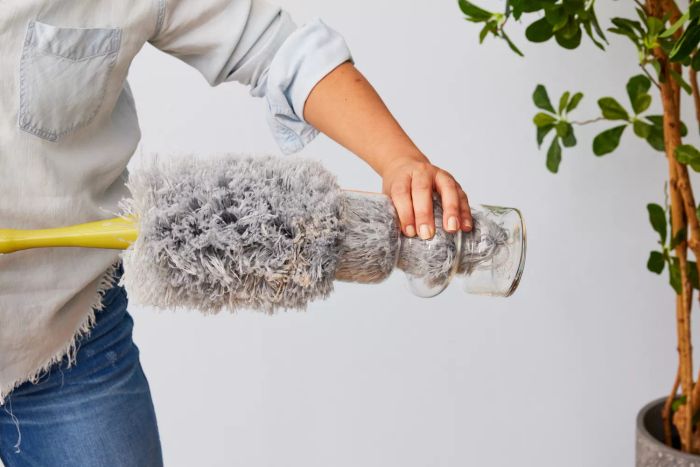 A person is using the DocaPole Microfiber Duster with Extension Pole.