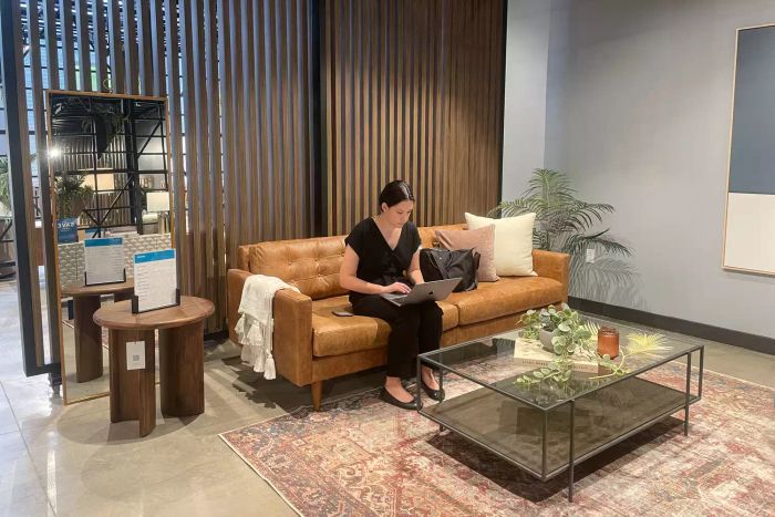 An individual seated on the Joybird Eliot Apartment Sofa