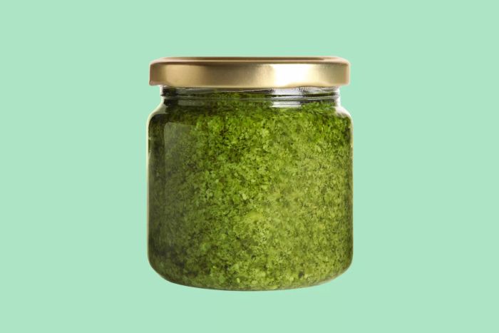 Pesto jar against a green backdrop