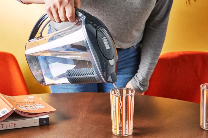 A person pouring water from the Brita Rapids Stream Water Pitcher into a glass