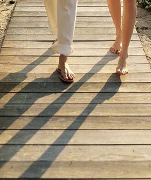 Two people strolling along a beachside boardwalk