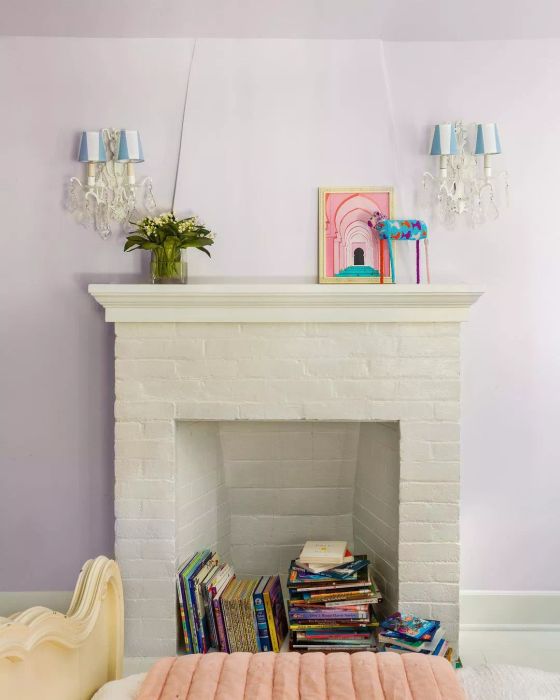 A fireplace filled with a stack of books inside.