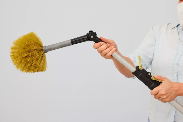 A person fine-tunes the DocaPole Microfiber Duster with Extension Pole.