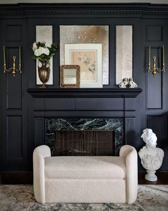 A black fireplace mantel complemented by brass details.