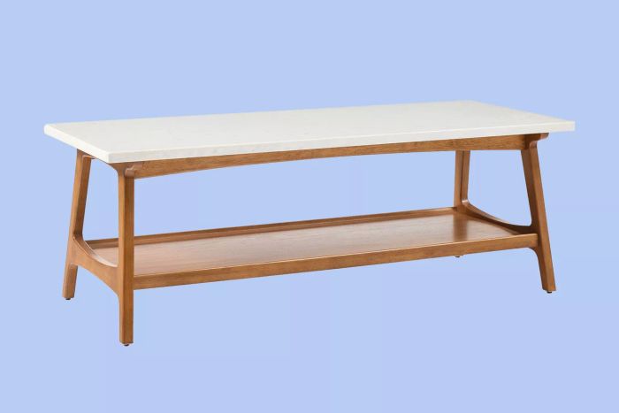 The West Elm Reeve Coffee Table set against a blue backdrop