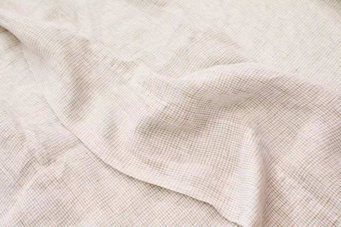A close-up shot of the Crate & Barrel Garden Green Grid Natural Hemp Fiber Queen Bed Sheet Set.