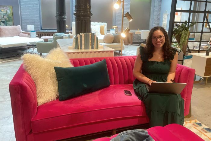 An individual seated on the Joybird Chelsea Loveseat