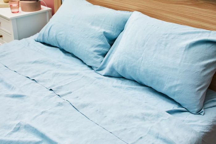 Close-up of a bed with pillows and the Tuft & Needle Hemp Sheet Set