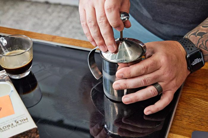 Close-up of someone using the HIC Fino Milk Frother.