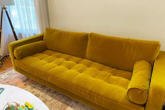 A golden sofa from Article placed in a living room setting