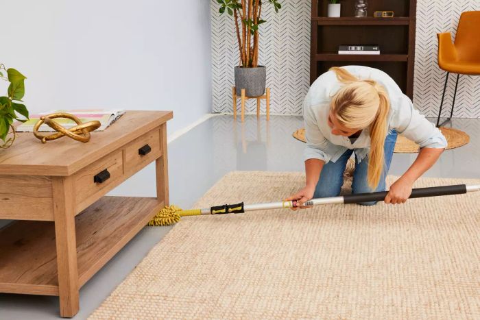 A person uses the DocaPole Microfiber Duster with Extension Pole to clean dust from various surfaces.