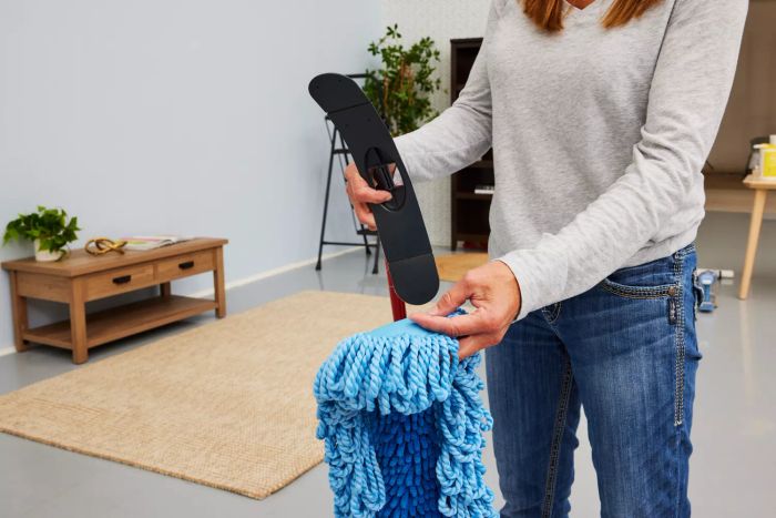 A person is putting together the O-Cedar Dual-Action Microfiber Sweeper Dust Mop.