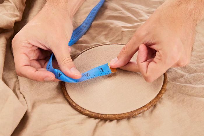 A person measures a section of the Lands' End 120 Thread Count Garment Washed Cotton Hemp Blend Bed Sheet Set using a measuring tape.