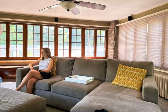 An individual seated on Crate & Barrel's Axis Sectional Sofa