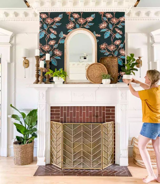 Floral wallpaper behind the fireplace mantel adds a touch of charm.