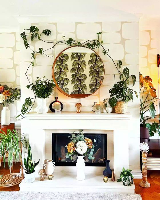 A fireplace mantel adorned with lush greenery above.